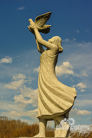 Female in dress holding bird sculpture