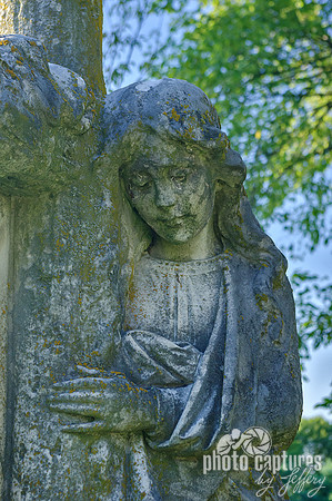 Female sculpture hand on wood log cross
