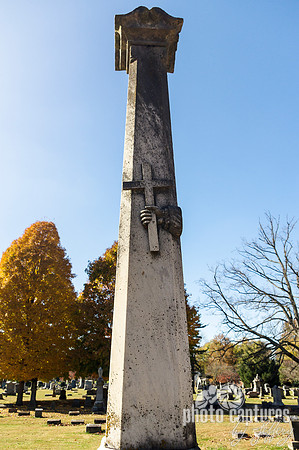 Obelisk with hand holding cross and bible on the top