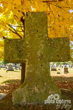 Stone cross fall colorful leaves cemetery