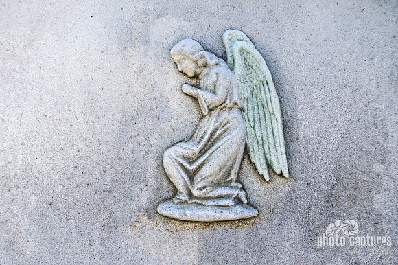 Winged kneeling angel emblem