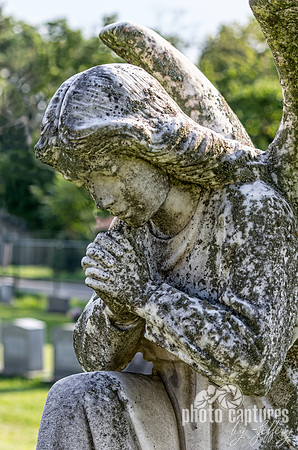 Angel sculpture with hands in prayerful repose