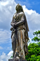 Female Sculpture Hands Resting on Anchor Side View